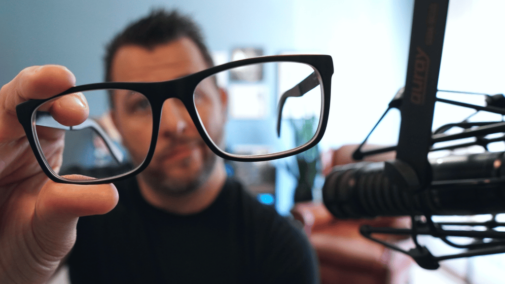 man holding glasses to focus