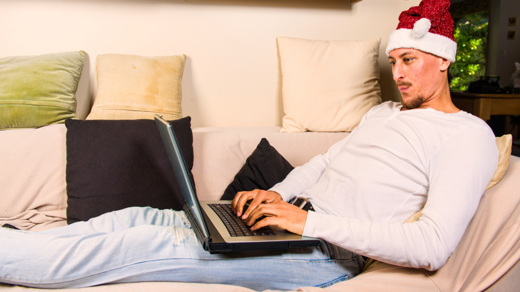 man on laptop santa hat