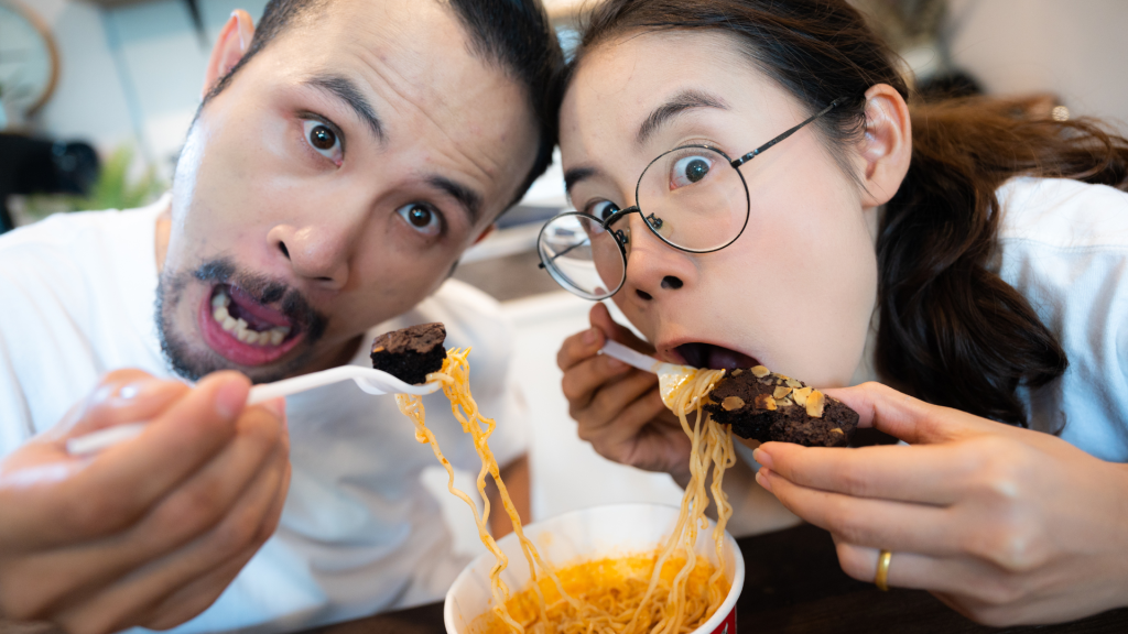 woman and man eating noddles on brownies