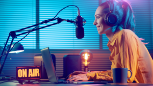 woman on microphone on air typing on computer
