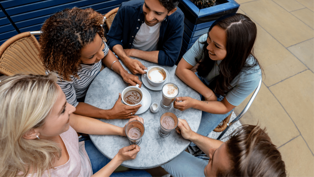 people drinking coffee around a round table in a public space